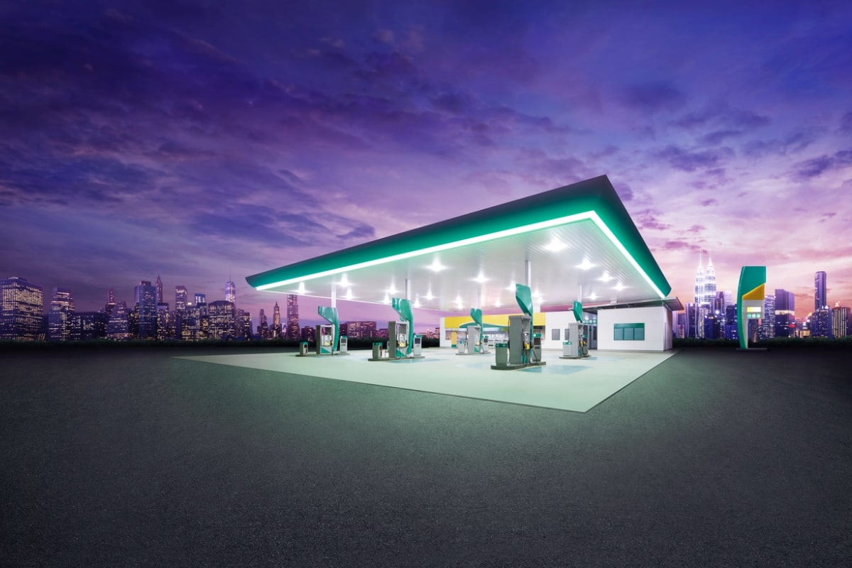 gas station at night with city buildings in the background