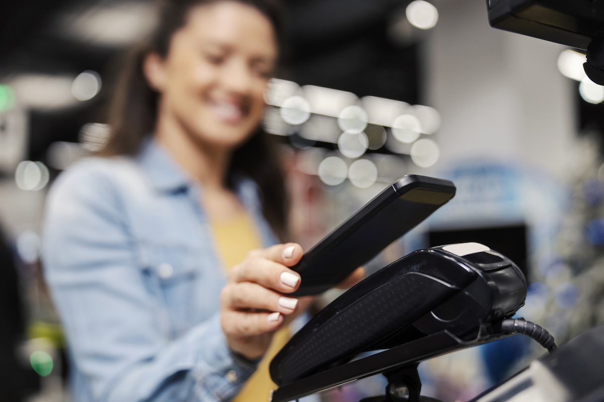 woman scanning her loyalty account at the gas station checkout